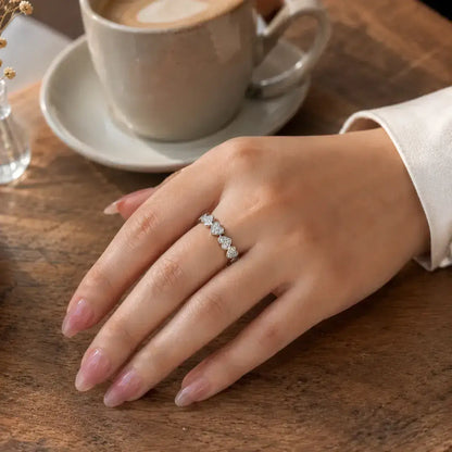 Anel corações em prata 925 cravejados com moissanite em close na mão da modelo