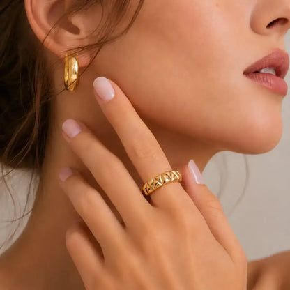 Anel em prata 925 dourado com design piramidal em close na mão da modelo