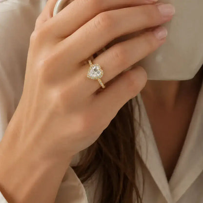 Anel halo coração em prata de lei dourada com moissanite na mão da mulher lifestyle