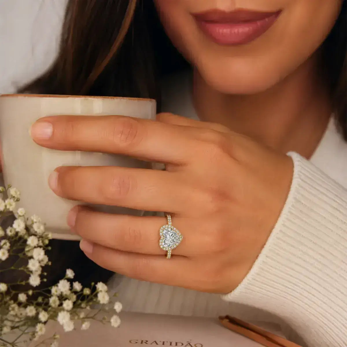 Anel coração em prata 925 dourada com moissanite na mão da mulher