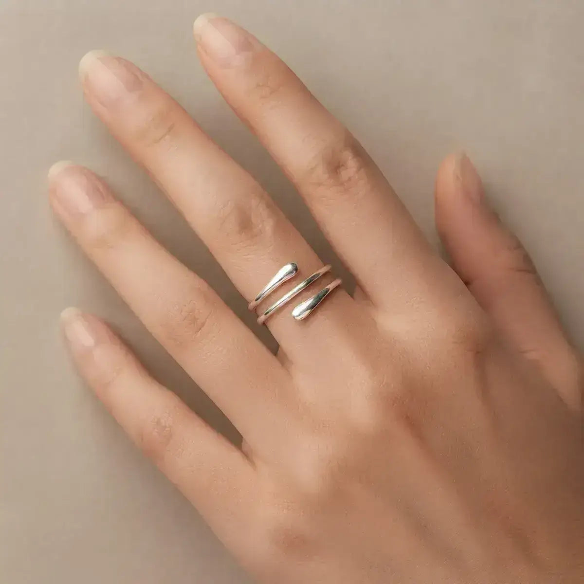Anel ajustável em prata 925 com design aberto em close na mão da modelo