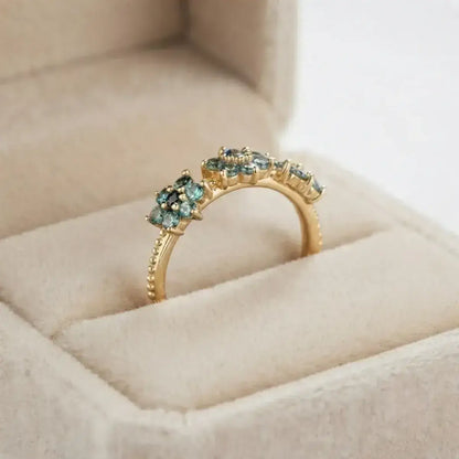 Anel em prata 925 banhado a ouro com design floral em moissanite ciano numa caixa de joias