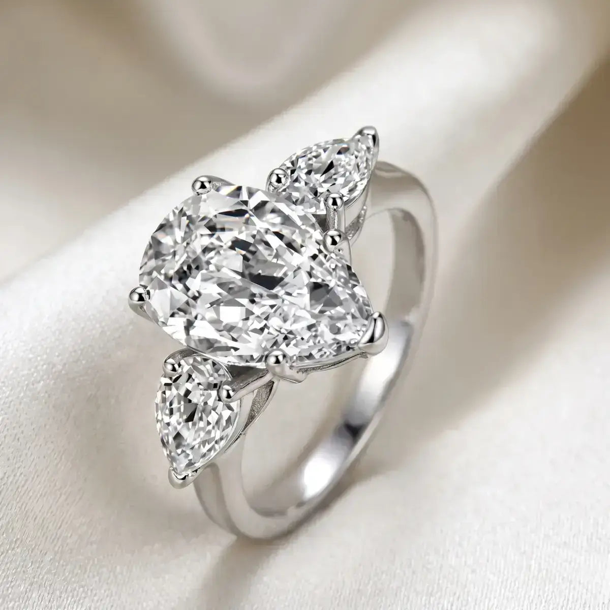 Anel solitario gota em prata de lei com moissanite, em cima de um tecido off white