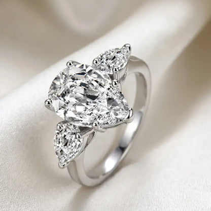 Anel solitario gota em prata de lei com moissanite, em cima de um tecido off white
