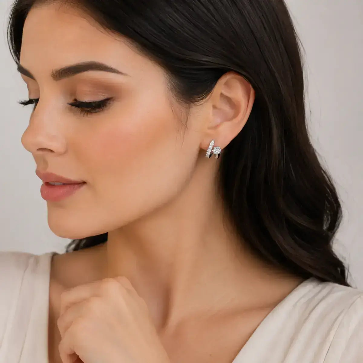 Brincos de argolas assimetricos em prata de lei com moissanite usados por uma modelo elegante