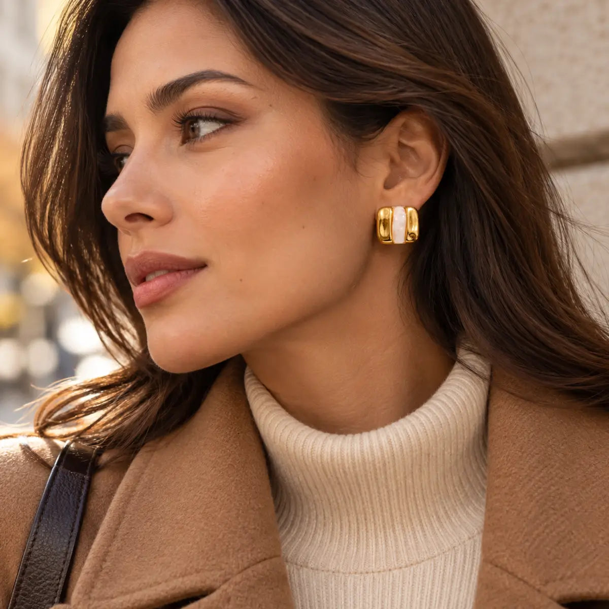 Brincos de resina geométricos bege usados por modelo com look de Outono