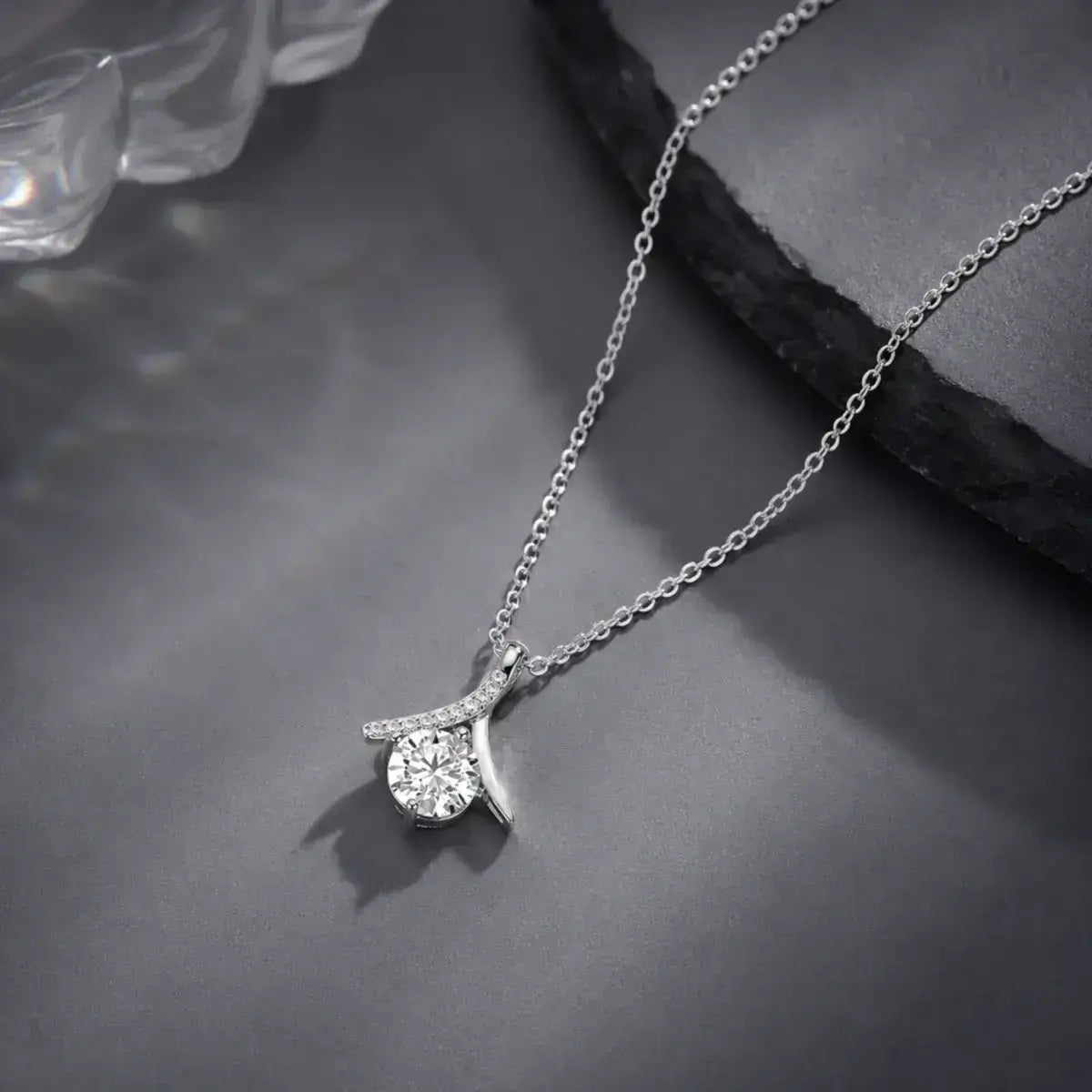 Colar solitário em prata 925 com moissanite e pendente inspirado no símbolo do infinito sobre fundo minimalista elegante