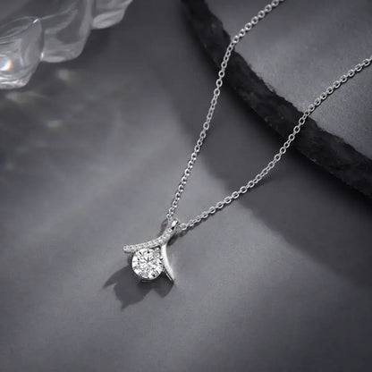 Colar solitário em prata 925 com moissanite e pendente inspirado no símbolo do infinito sobre fundo minimalista elegante