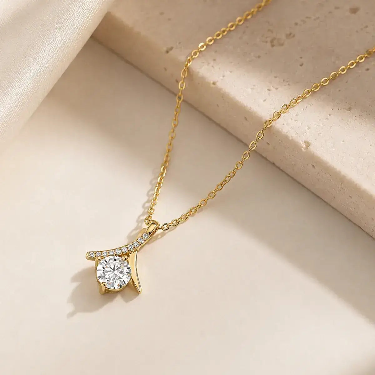 Colar solitário em prata 925 dourado com moissanite e pendente inspirado no símbolo do infinito sobre fundo sofisticado em tons claros