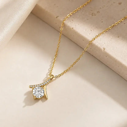 Colar solitário em prata 925 dourado com moissanite e pendente inspirado no símbolo do infinito sobre fundo sofisticado em tons claros