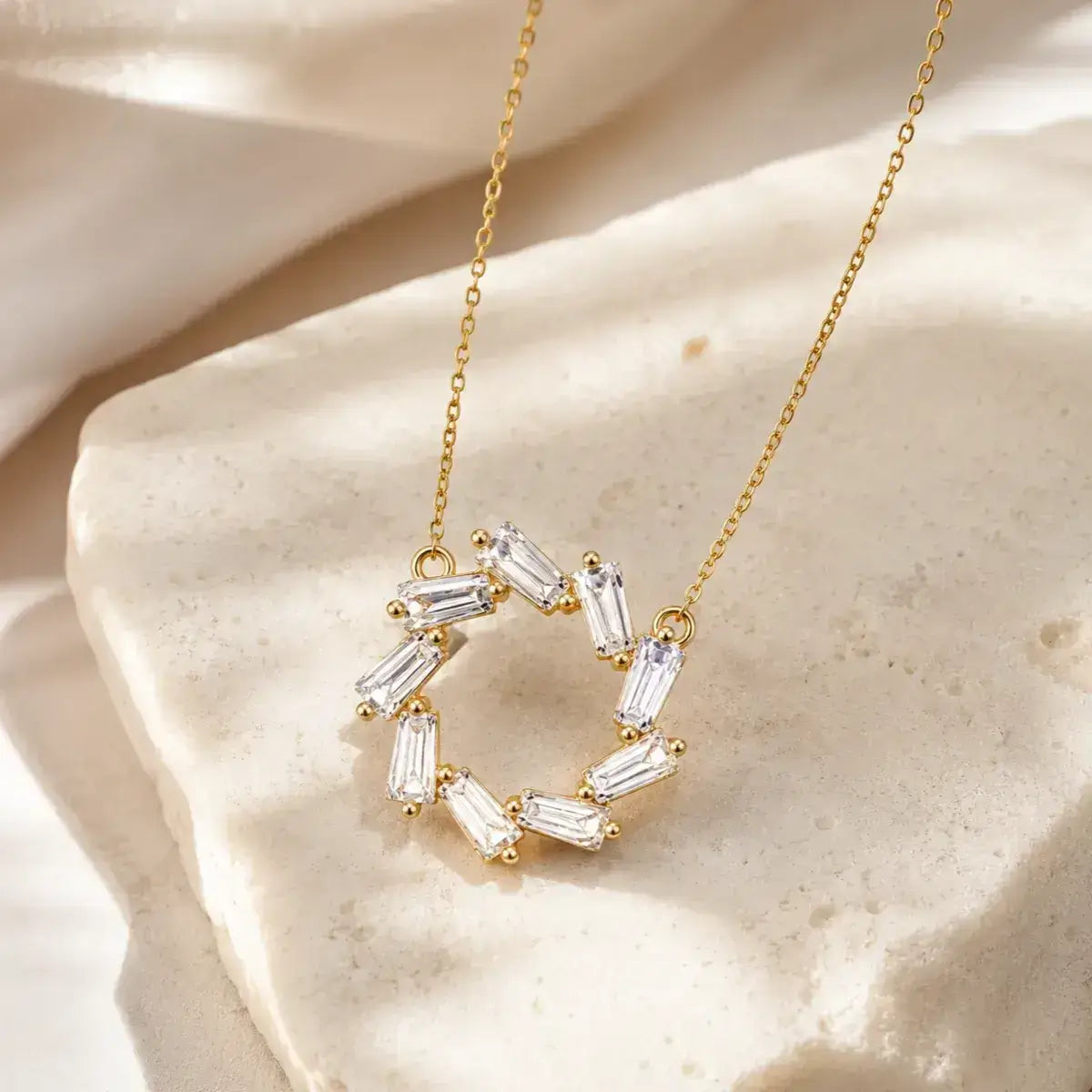Colar em Prata de Lei 925 dourado com pendente circular de zircónias baguete sobre superfície elegante