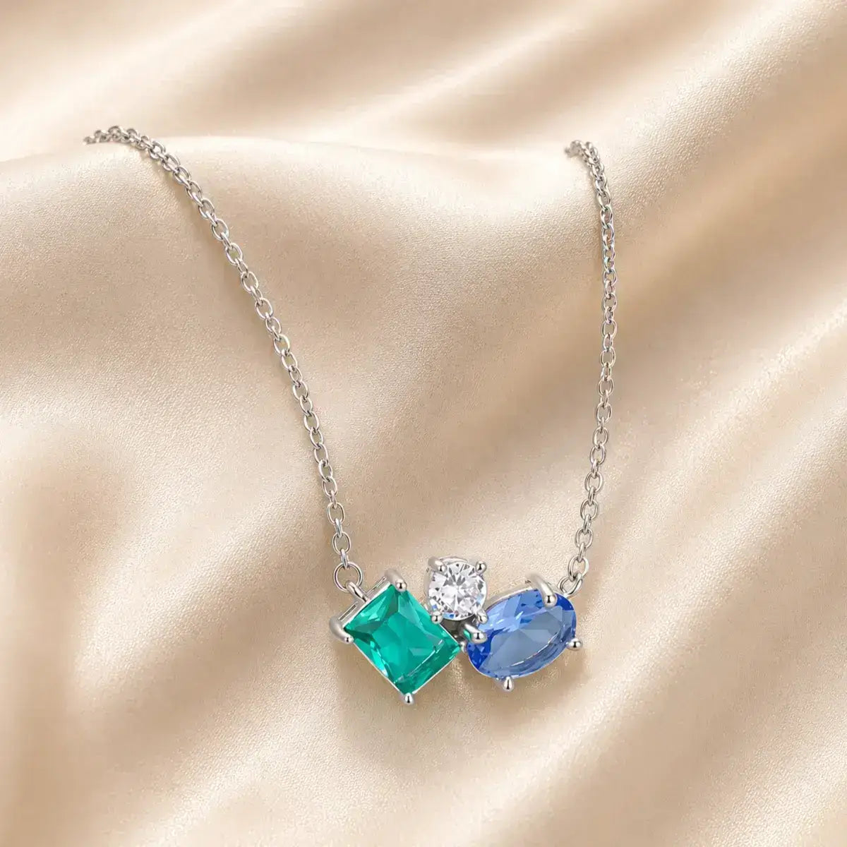 Colar de prata de lei 925 com zircónia brilhante e cristais azul e verde sobre tecido acetinado bege