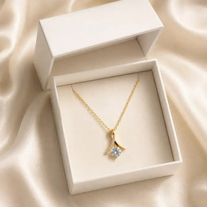 Colar solitário em prata 925 dourada  com moissanite e pendente inspirado no símbolo do infinito em caixa de joias branca sobre tecido acetinado