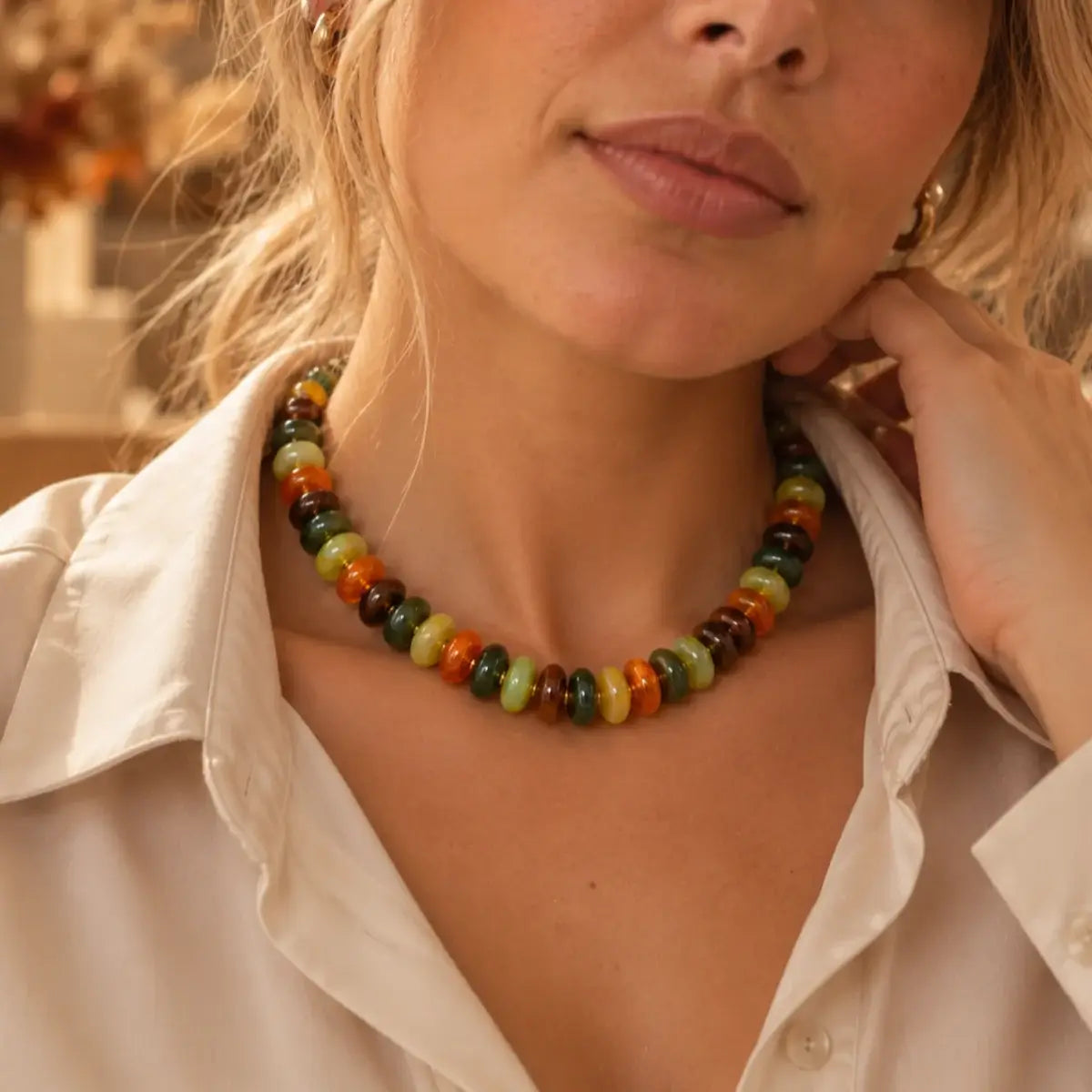 Colar de resina com contas multicoloridas usado com camisa bege