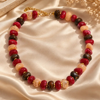 Colar de resina com contas multicoloridas vermelho, bege, castanho, sobre tecido de seda champagne