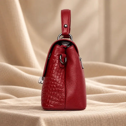 Mala a tiracolo em pele com textura croco e acabamento elegante para mulher com vista lateral