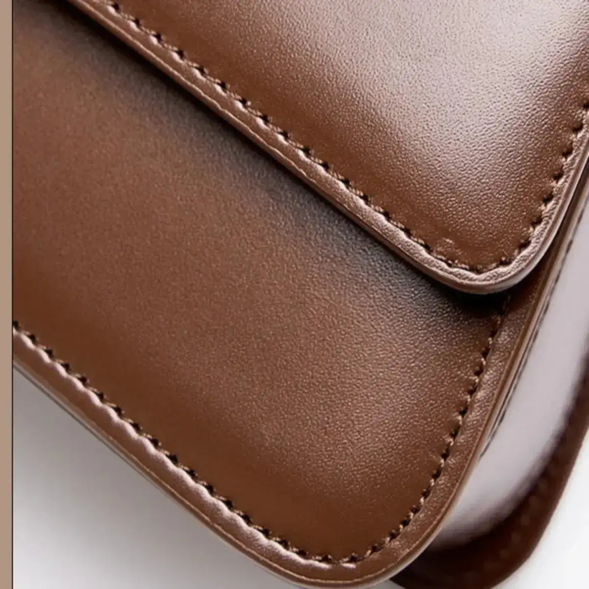 Detalhe da pele genuína da Mala Celeste com acabamento liso e costuras premium