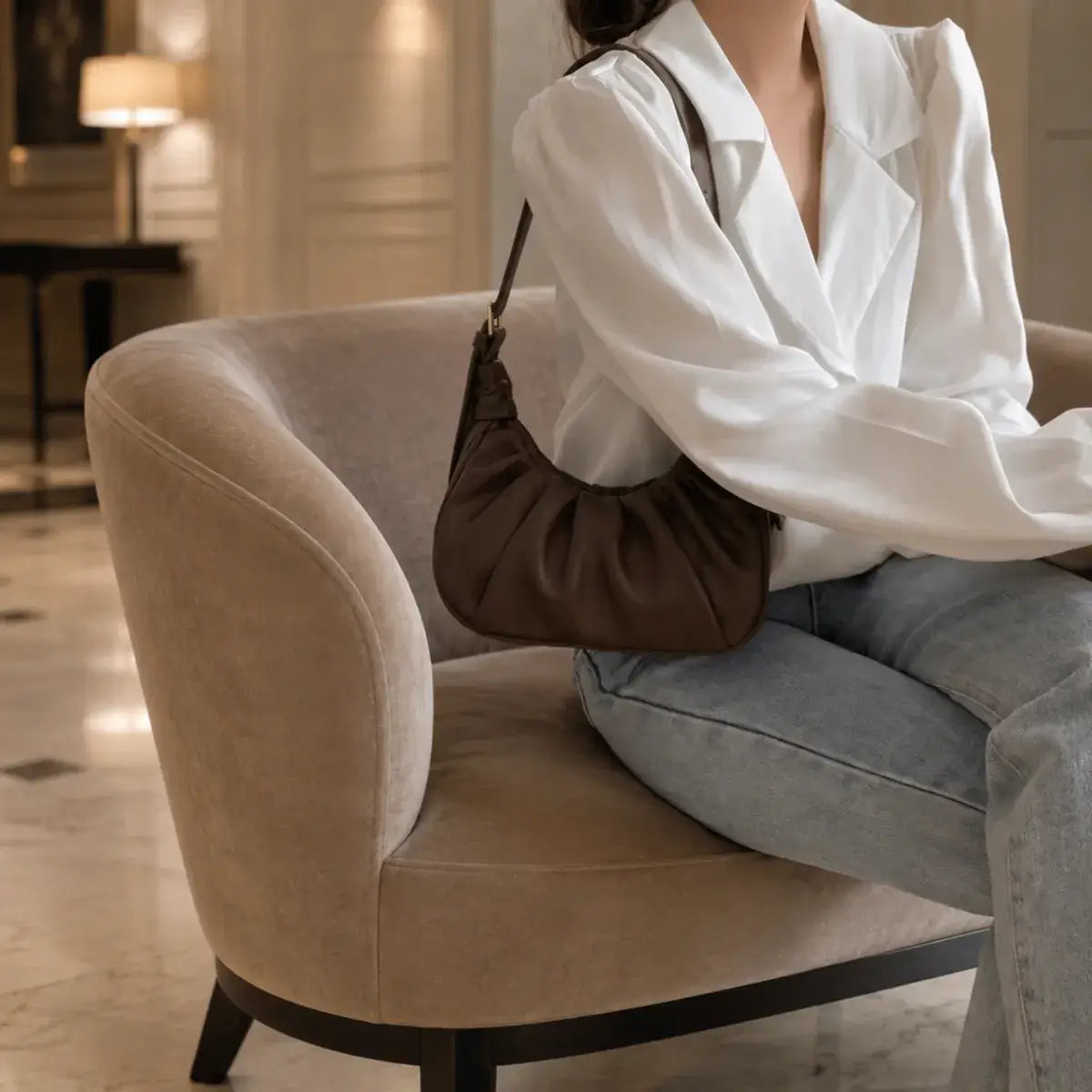 Modelo com a mala de ombro Chloe castanho escuro num elegante hall de hotel