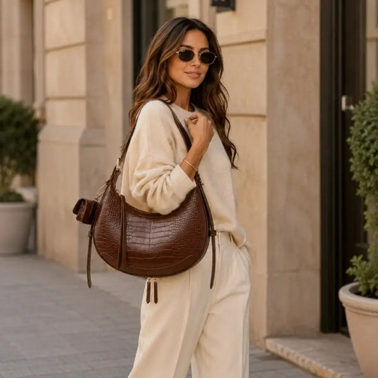 Mala de ombro em pele castanha design meia lua na modelo lifestyle com alça ajustável