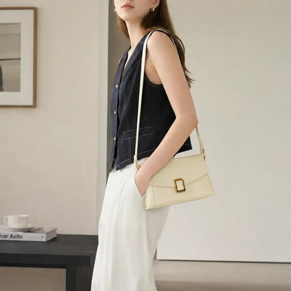 Modelo a usar a mala de ombro pequena em pele genuína Aurelia off white em modo tiracolo