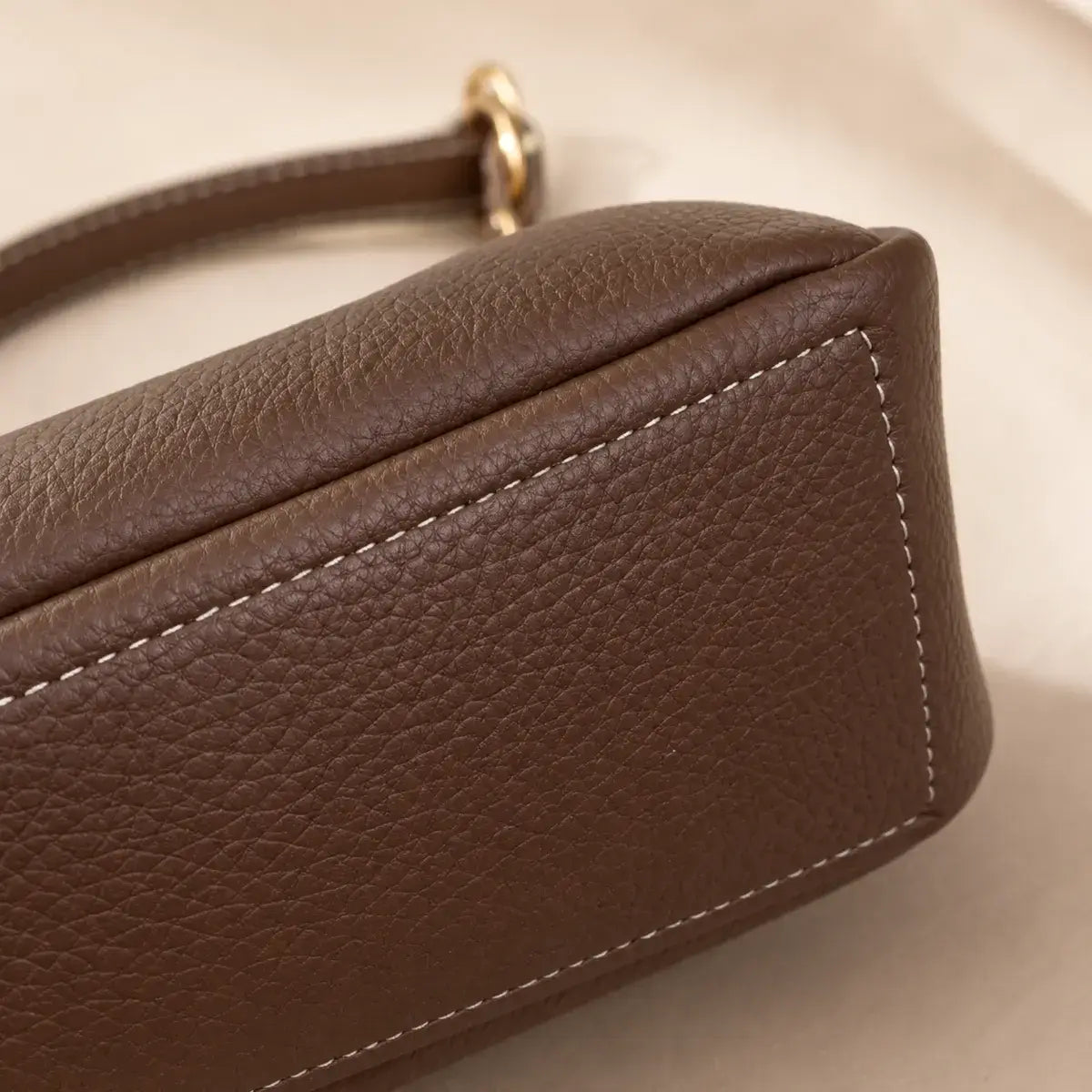 Detalhe da base da Mala Tiracolo Élia em pele sintética premium castanha com acabamento texturizado