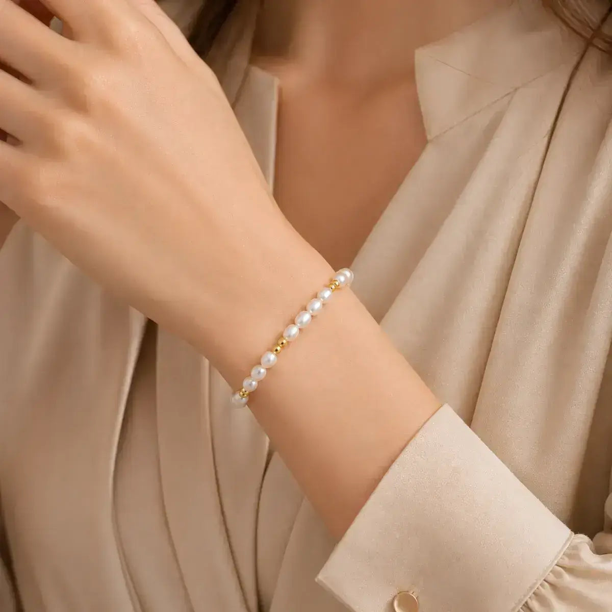 Pulseira com pérolas em prata de lei dourada no braço da modelo