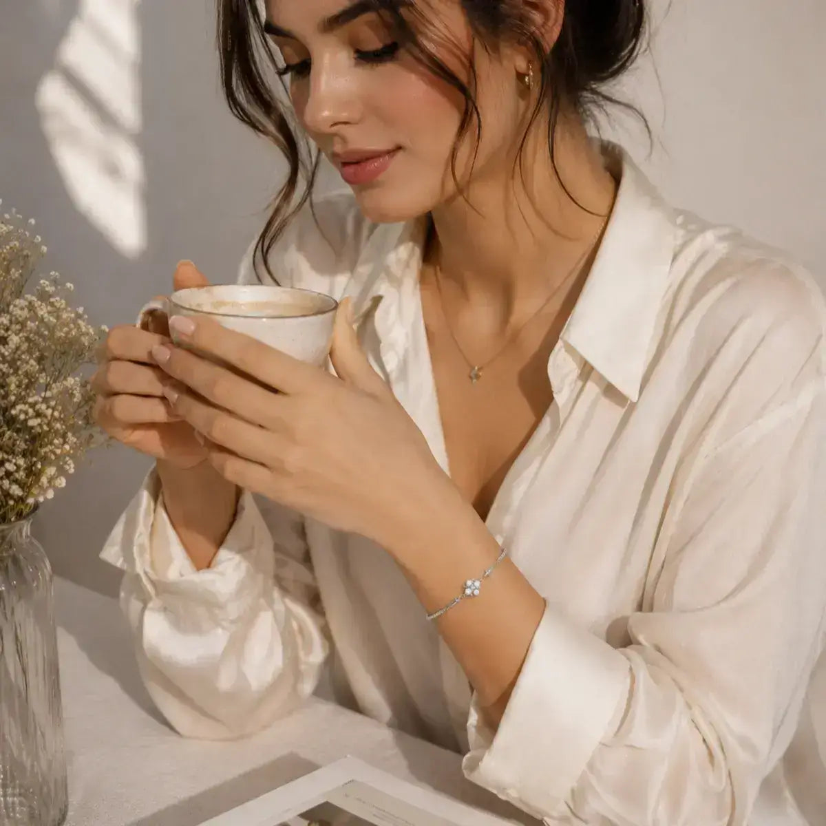 Modelo com coque usando pulseira em Prata 925 com pérola natural e moissanite em ambiente lifestyle elegante