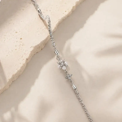 Pulseira em Prata de Lei 925 com pérola natural e moissanites em composição elegante sobre fundo bege minimalista