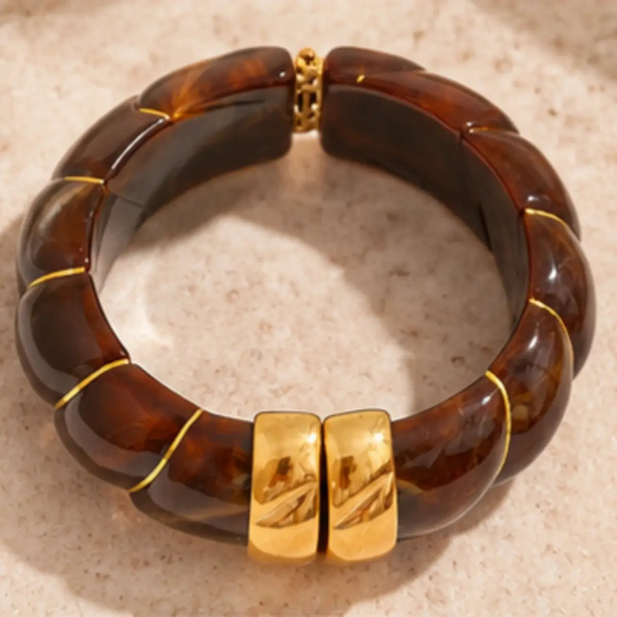 Pulseira de resina castanha larga com design geométrico vista de cima