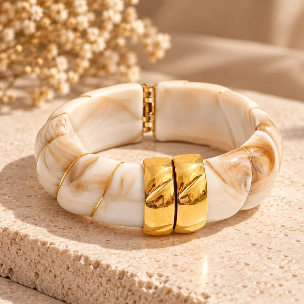 Pulseira de resina bege larga com design geométrico e acabamento dourado